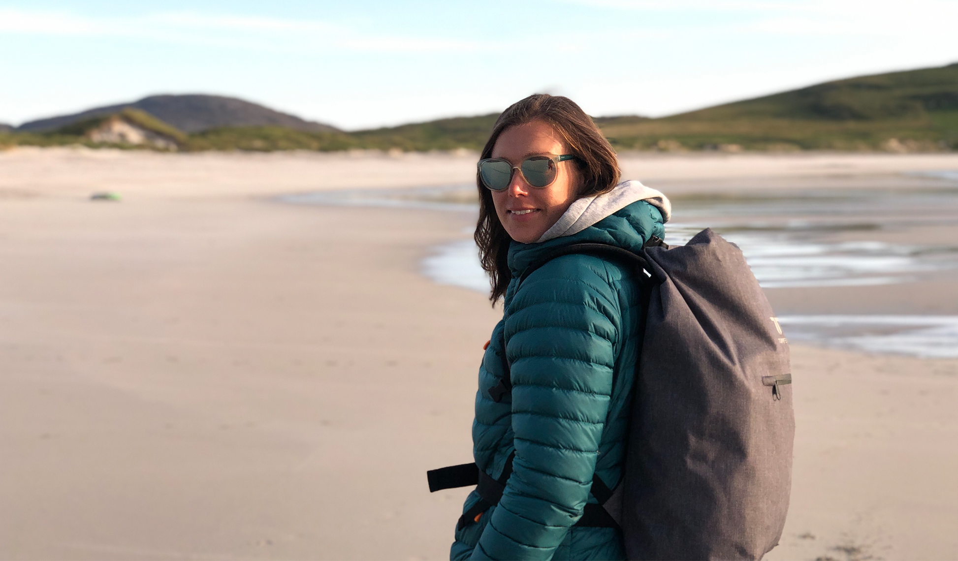 Lady wearing sustainable rucksack walking on beach